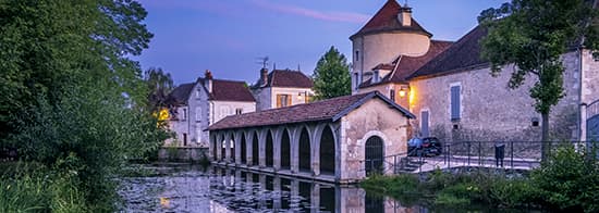 Kleine Kirche in Chablis mit Fluss im Vordergrund