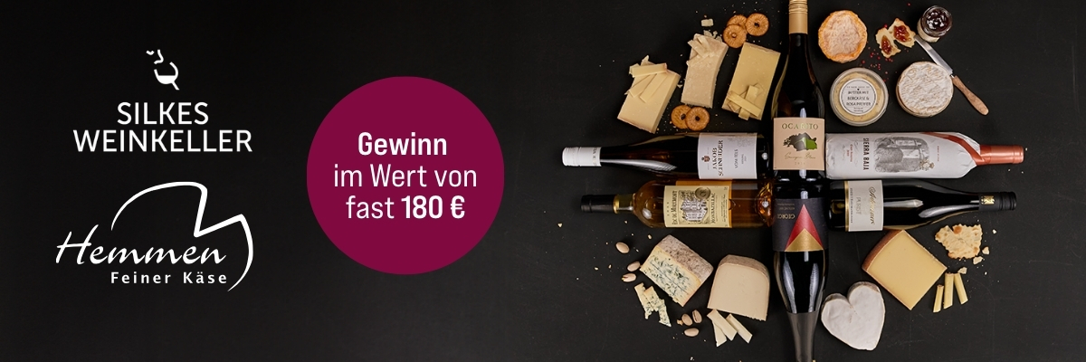 Gewinnspiel Käse Hemmen mit Weinflaschen und Käse auf dunklem Hintergrund