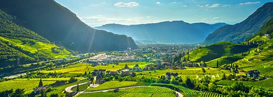 Südtiroler Panorama mit Bergen, Weinbergen und einem kleinen Örtchen