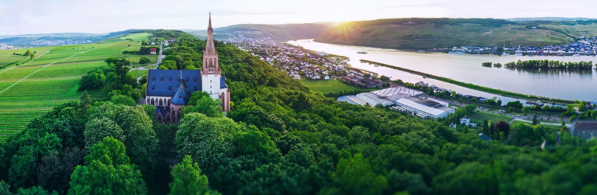 Rheingau Panorama mit kleiner Kirche und dem Rhein, am Ufer kleines Örtchen