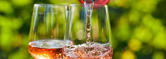 Roséwein wird in zwei Gläser geschüttet