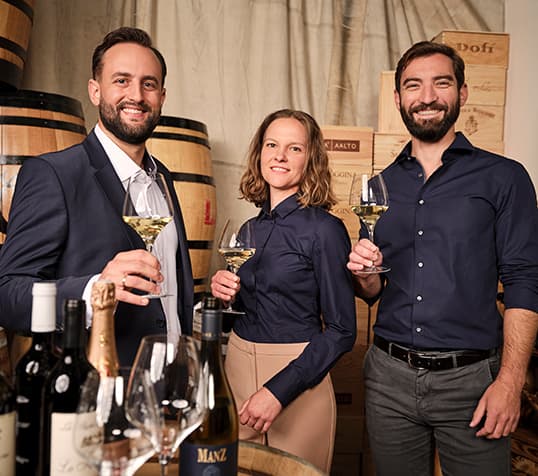 Eine Frau und zwei Männer mit Weingläsern