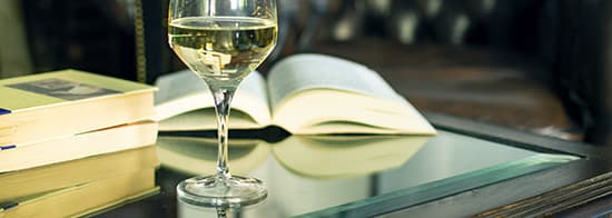 Weinglas und Buch auf Tisch