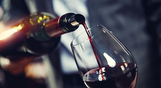 Mann füllt Wein in Glas