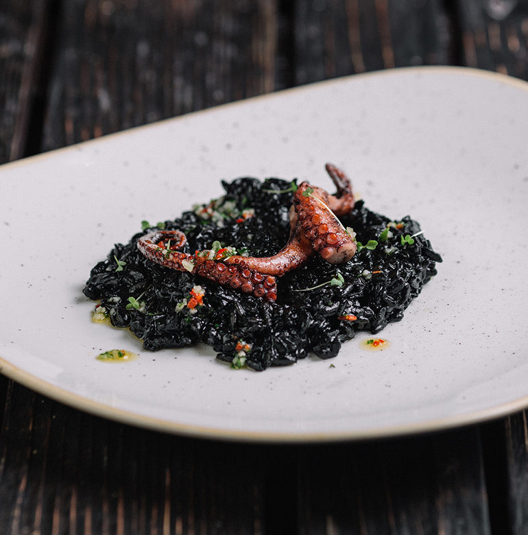 Schwarzes Risotto mit Tintenfisch ist ein extravaganter Klassiker der Küche Venetiens. Wir zeigen Ihnen, wie Sie Ihre Gäste erstaunen und geben Weinempfehlungen.