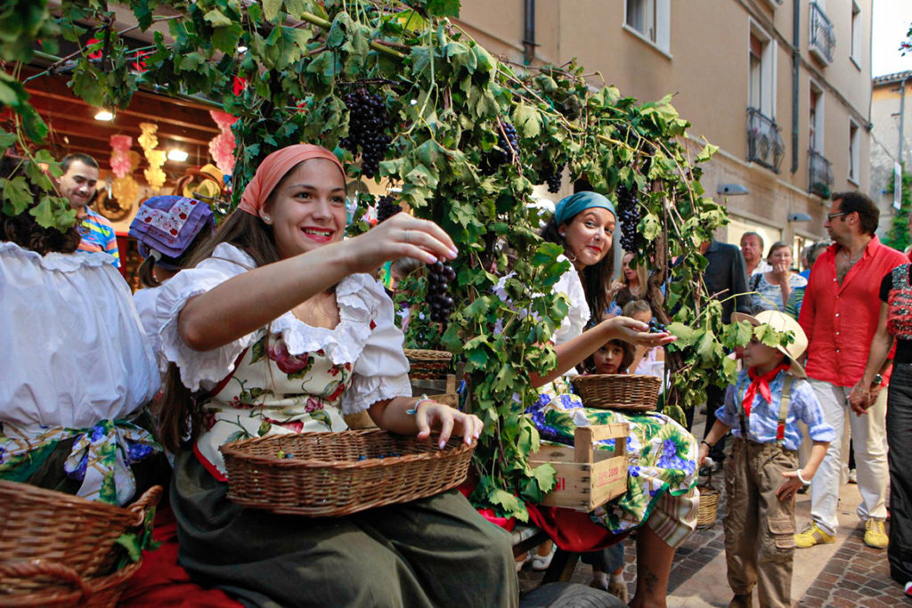 Frauen verteilen Weintrauben auf dem „Festa dell’Uva e del Vino“ in Bardolino | Silkes Weinkeller