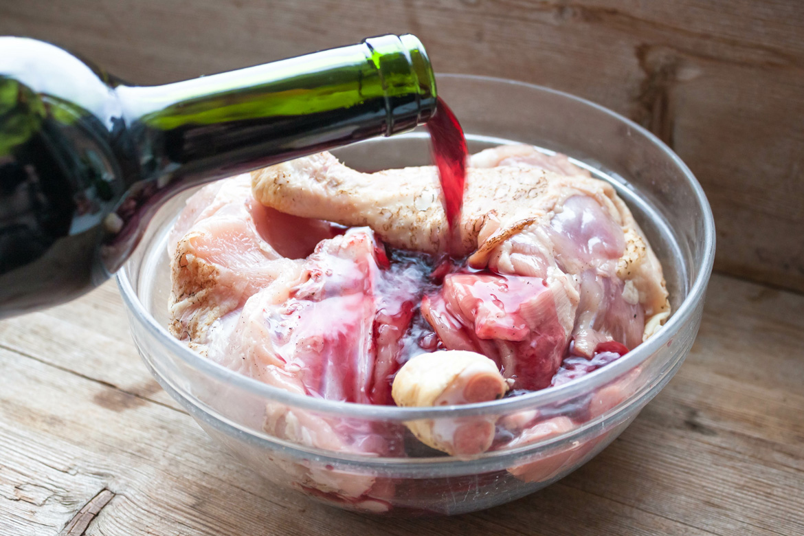 Wein in Schüssel mit Hähnchen gegossen