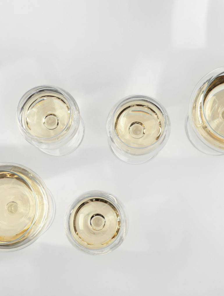 verschiedene Weingläser gefüllt mit Weißwein