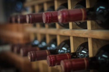 Weinregal gefüllt mit Rotweinflaschen