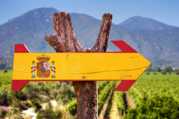 Spanische Flagge als Holzwegweiser in Pfeilform