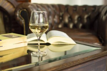 Ein Weinglas mit Buch auf einem Tisch