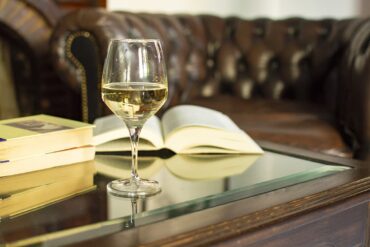weinglas buch Ein Weinglas mit Buch auf einem Tisch | KI-generiert