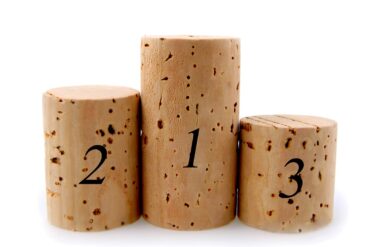 rekord Drei unterschiedlich Große Weinkorken wie ein Siegerpodest aufgestellt.